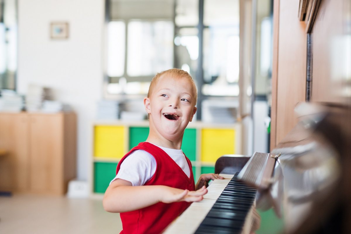 Little boy playing piano and smiling