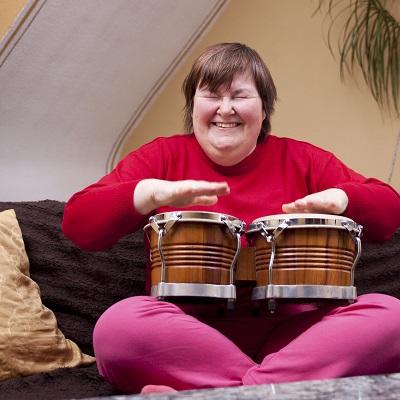 Woman playing the bongos and smiling